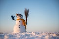 Snowman with broom on snowy field