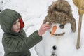 Snowman and child in the yard Royalty Free Stock Photo