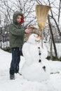 Snowman and child in the yard Royalty Free Stock Photo