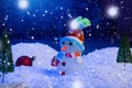 Snowman with Christmas balls on snow over fir-tree, night sky and moon. Shallow depth of field. Christmas background Royalty Free Stock Photo