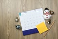 Snowman and christmas decoration with calendar on wooden table background. Planning ideas