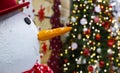 Snowman Christmas decorative object on vivid colorful garland illumination lighting unfocused background indoor