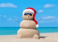 Snowman in Christmas Santa hat and sunglasses at ocean beach