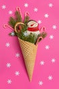 Snowman, Christmas tree twigs and lollipop in a waffle cone. Red background with snowflakes. An original sweet gift Royalty Free Stock Photo