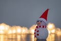 Snowman figurine dressed as Santa Claus and blurred fairy lights Royalty Free Stock Photo