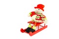 Snowman figurine sitting on red sledge Royalty Free Stock Photo