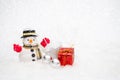 Snowman with gift box is standing in snowfall, Merry Christmas a Royalty Free Stock Photo