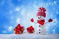 Snowman and gift boxes in winter snowy background. Christmas or New year greeting card Royalty Free Stock Photo