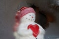 Snowman holding heart looking out window