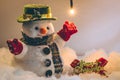 Snowman and light bulb stand among pile of snow at silent night, Merry christmas and Happy new year night. Royalty Free Stock Photo