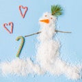 Snowman made of artificial snow on a blue background. Caramel hearts. New Year card Royalty Free Stock Photo