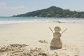 Snowman made of sand on a background of the tropical warm sea Royalty Free Stock Photo