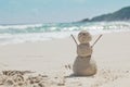 Snowman made of sand on a background of the tropical warm sea