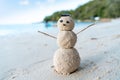 Snowman made of sand on a background of the tropical warm sea, New Year and Christmas Cards concept Royalty Free Stock Photo