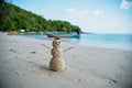 Snowman made of sand on a background of the tropical warm sea, New Year and Christmas Cards concept Royalty Free Stock Photo