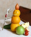 Snowman from oranges with broom and fruit