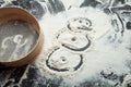 Snowman painted on a flour on a black background. Festive and Christmas baking