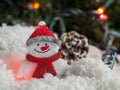 Snowman and a pine cone on decorative snow under a Christmas tree Royalty Free Stock Photo