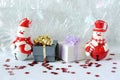 Snowman posed next to gifts with shiny knots on a Christmas holiday decor