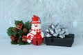 Snowman posed next to gifts with shiny knots on a Christmas holiday decor