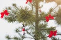Snowman and red bows are hanging on Christmas pine tree. Natural photo in frozen forest. Happy holidays postcard. New year`s Royalty Free Stock Photo