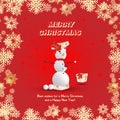 A snowman in a red cap emerges from a gift package on a red background and golden snowflakes. Festive greeting card for Christmas Royalty Free Stock Photo