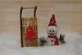 Snowman in a red cap with wooden sleigh Royalty Free Stock Photo
