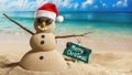 Snowman Sandman on Tropical Beach Wearing Santa Hat Sunglasses with Merry Christmas Sign Copy-Space Royalty Free Stock Photo