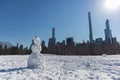 Snowman on the Sheep Meadow at Central Park in New York City during the Winter with the Midtown Manhattan Skyline in the Backgroun