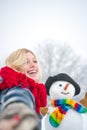 Snowman in snow forest. People in snow. Snowman and snow day. Winter portrait of young woman in the winter snowy scenery Royalty Free Stock Photo