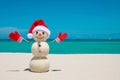 Snowman. Snowman with red Santa Claus hat and mittens. Merry Christmas and Happy New Year. Sandy Snowman on the beach Royalty Free Stock Photo