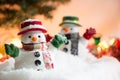 Snowman stand among pile of snow at silent night with a light bulb, light up the hopefulness and happiness in Merry christmas Royalty Free Stock Photo
