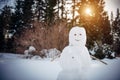 Christmas Snowman in sunny winter forest against the trees and white snow. New Year, active games outdoor Royalty Free Stock Photo