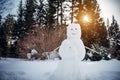 Snowman in sunny winter forest against the trees and white snow. New Year, active games outdoor Royalty Free Stock Photo