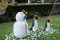 Snowman and three penguins on a green lawn, garden sculpture