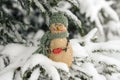 Snowman, toy on the background of a snowy Christmas tree. Snowing. Selective focus, blurred winter background. The concept of the
