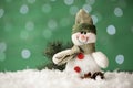 Snowman toy and Christmas decor on snow against blurred festive lights, closeup. Space for text Royalty Free Stock Photo