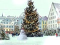 snowman white Christmas tree illuminated snow flakes festive bokeh light on Town hall square in Tallinn Estonia holiday in cit