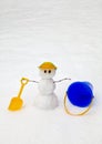 A snowman wishing he was at the beach with his pail and shovel Royalty Free Stock Photo