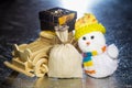 Snowman with wooden car, gift box and sack Royalty Free Stock Photo