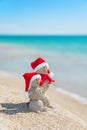 Snowmans couple at sea beach in christmas hat. New years holiday