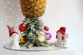 Snowmen near Christmas tree made from pineapple