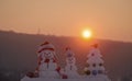 Snowmen with smiley faces in hats on evening landscape Royalty Free Stock Photo