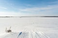Snowmobile tracks on a winter field. Sunny winter day with blue sky Royalty Free Stock Photo