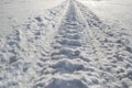 Snowmobile trail in the snow closeup. Snowmobile track on frozen river Royalty Free Stock Photo