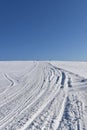 A snowmobile trail under a blue sky Royalty Free Stock Photo