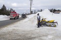 Snowmobiler rider chcks for traffic on city street