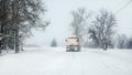 Snowplow highway maintenenace truck cleaning road completely white from snow in winter, dangerous driving conditions, view from Royalty Free Stock Photo