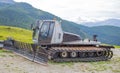 Snowplow parked in the summertime in a mountain landscape