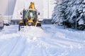 Snowplow plowing road during storm. Winter snow removal yellow large tractor Royalty Free Stock Photo